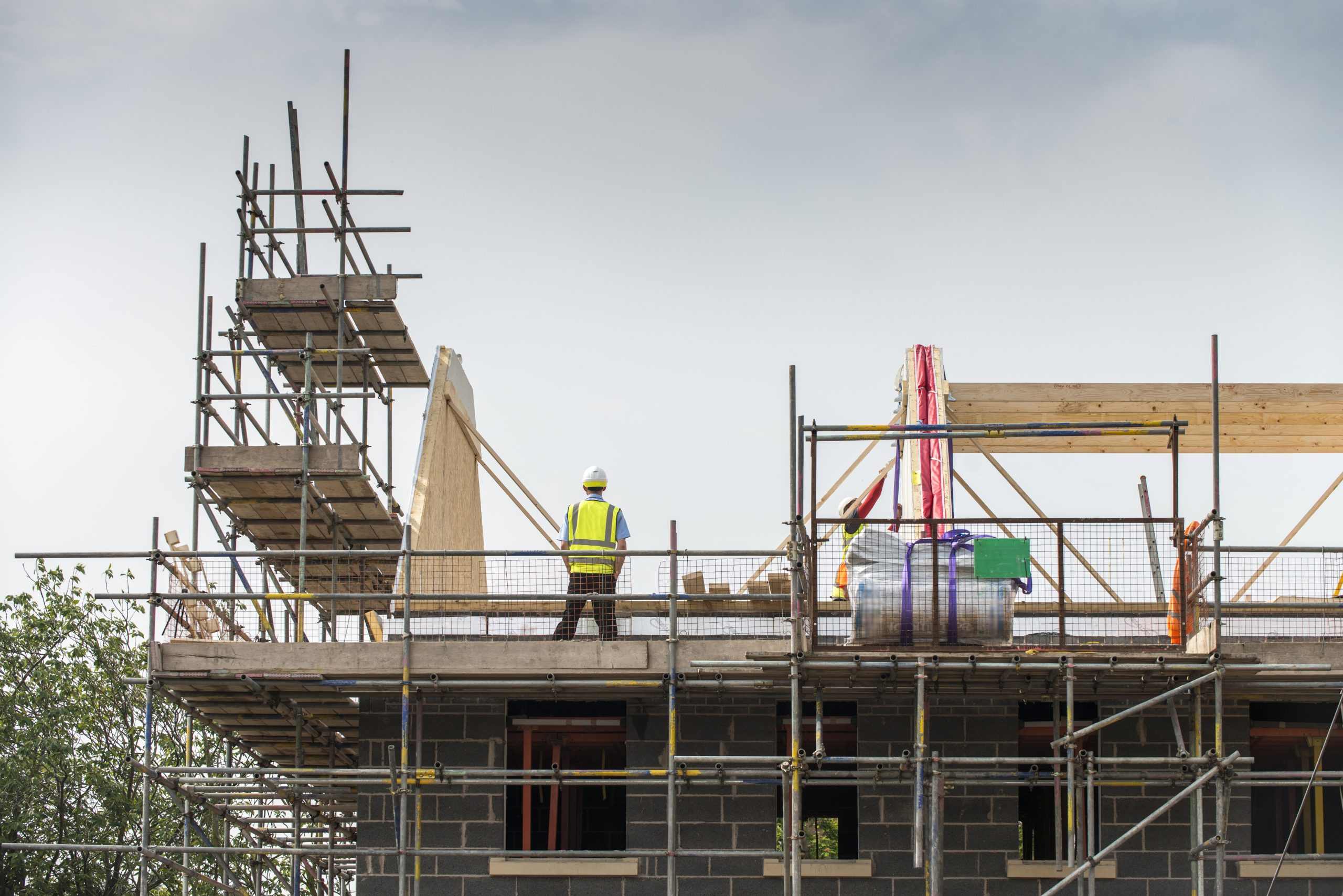 Worker working on roof of building